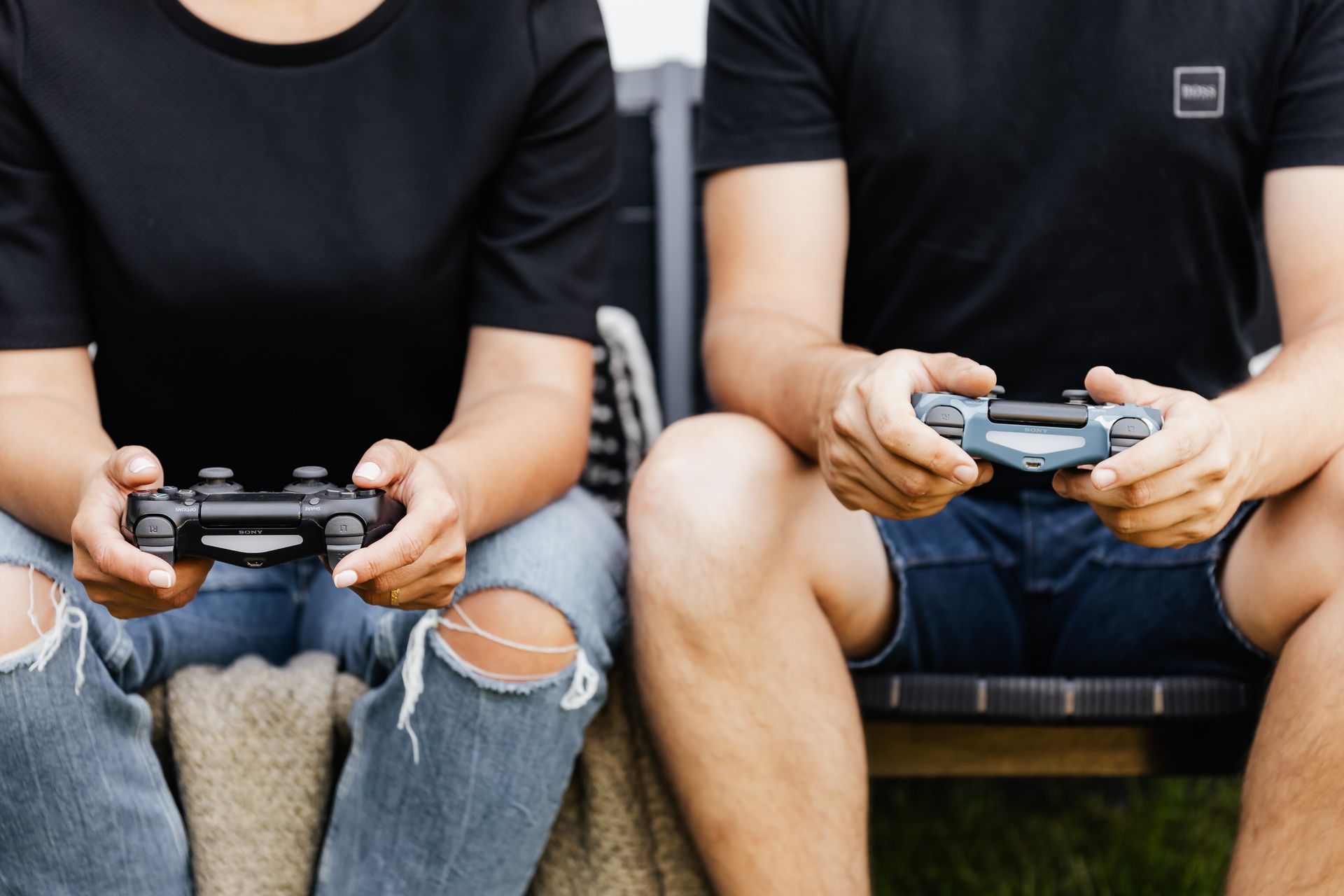Happy couple enjoying video games together with controllers on a sofa.
