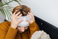 一位头部受伤的妇女在室内痛苦地托着头