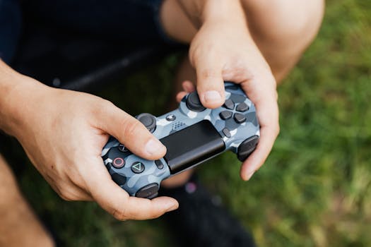 Man holding a camouflage gaming controller outdoors, focused on technology and leisure.