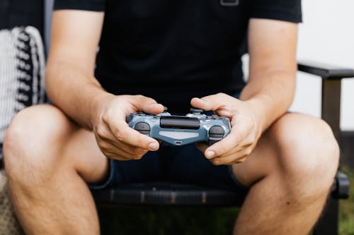 Person Sitting Holding a PlayStation Controller