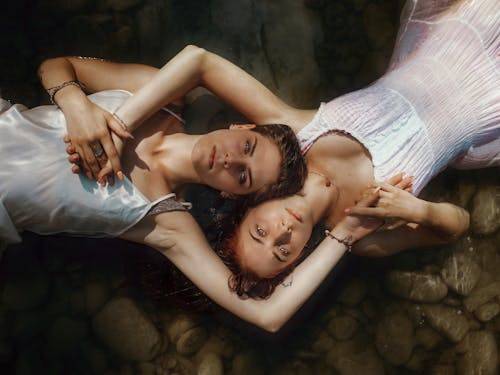 Calm female couple lying in water