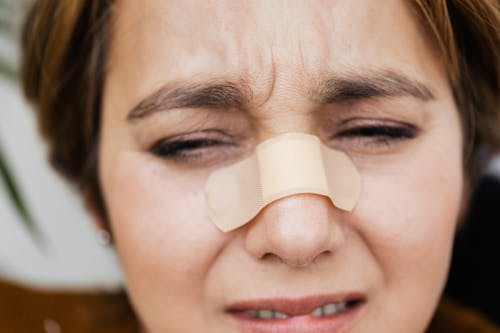
A Woman with a Bandage on Her Nose