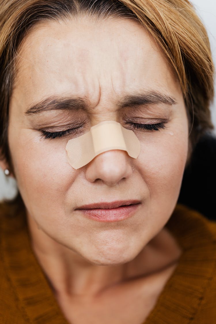 Woman With Band Aid On Her Face