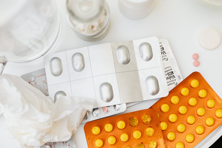 Blister Packs Of Assorted Medicines On White Surface 