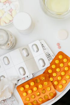 Close-up of various pills and blister packs on a white surface.