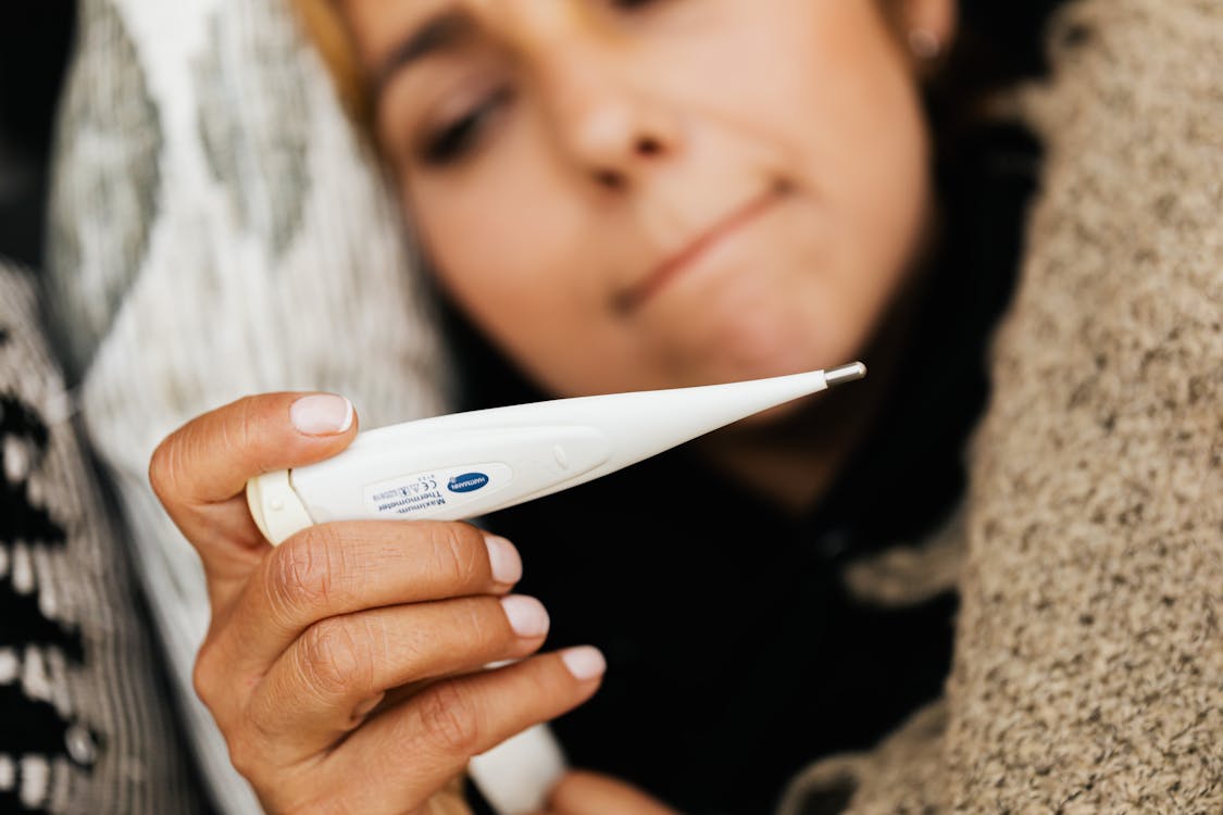 Free 
A Sick Woman Using a Digital Thermometer Stock Photo