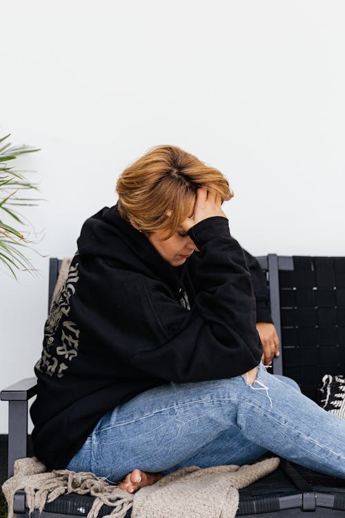 
A Woman in a Hoodie Having a Headache