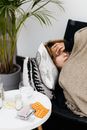 Medications Lying on Table by Ill Woman on Sofa