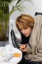 Woman Lying on the Couch Holding a Blister Pack