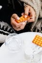 Person Holding an Orange Blister Pack