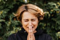 一位闭目合十的女子在户外深情地表达着情感