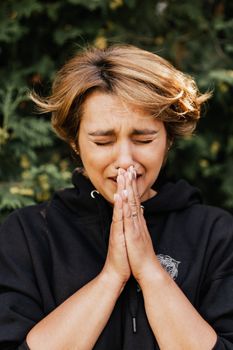 一个女人的特写，她闭着眼睛，双手合十祈祷，描绘出深刻的情感