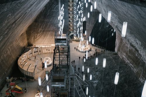 Free From above unrecognizable travelers walking in Rudolf Hall near various attractions in Salina Turda salt mine Stock Photo
