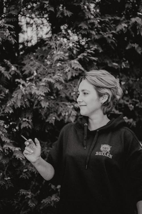 Grayscale Photo of Woman Holding a Cigarillo