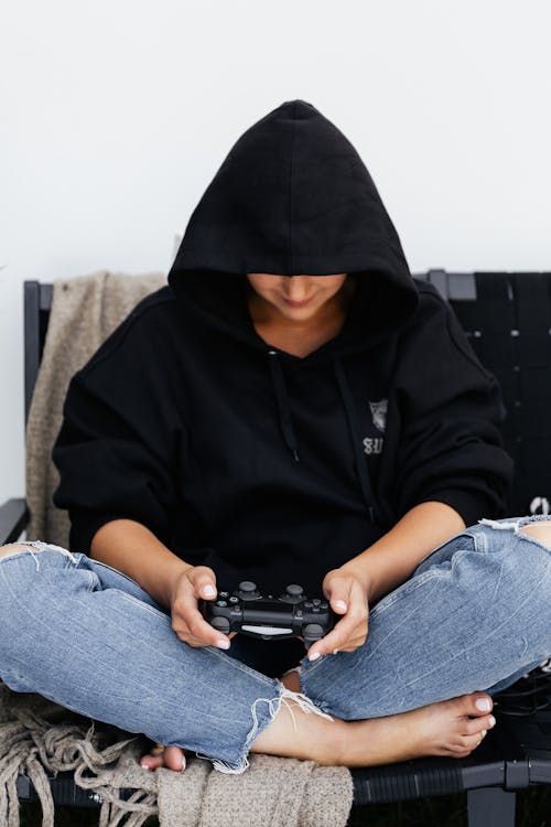 
A Person Wearing a Black Hoodie Playing a Video Game