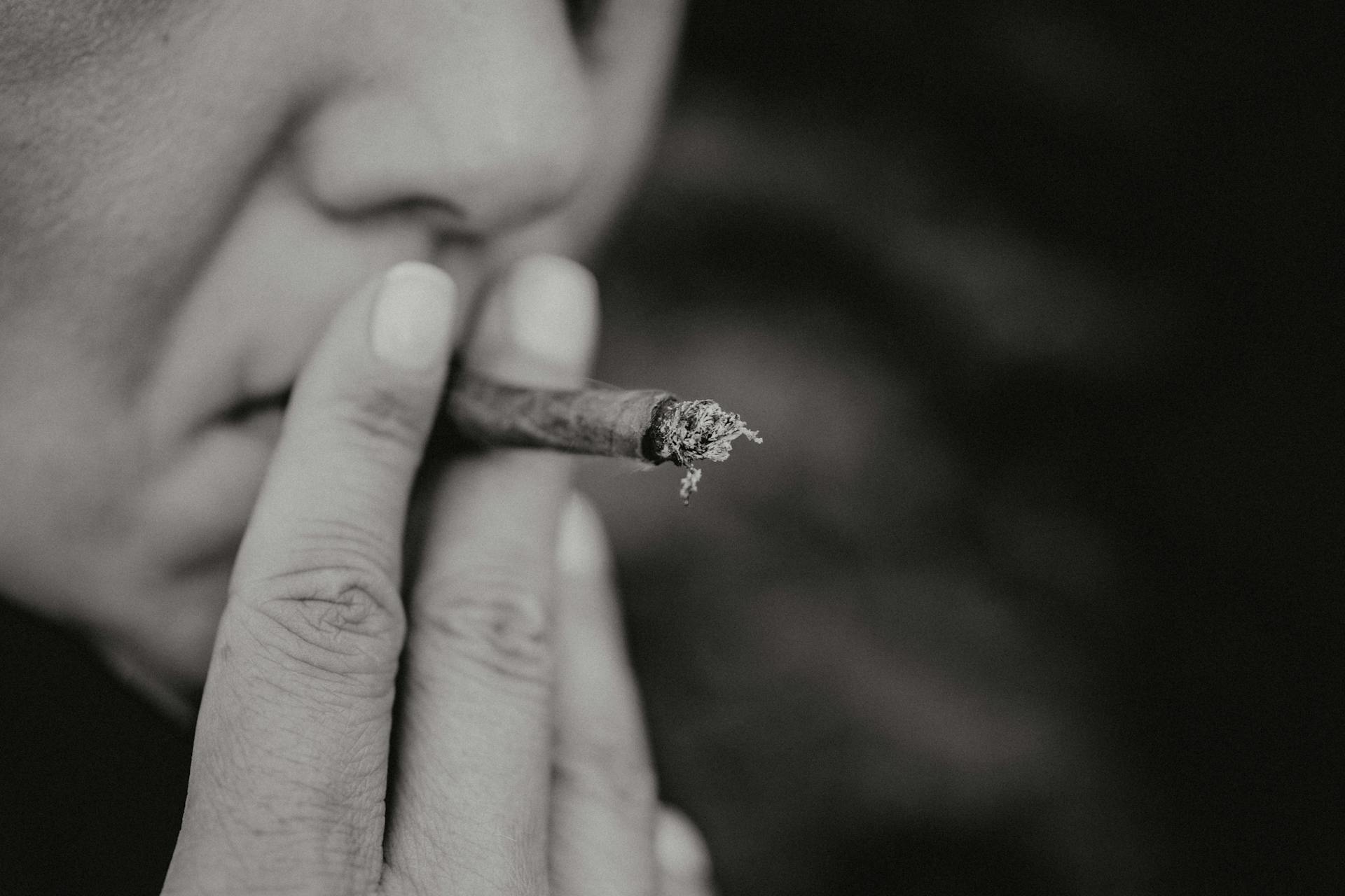 Close-up black and white portrait of a woman smoking a cigarette.