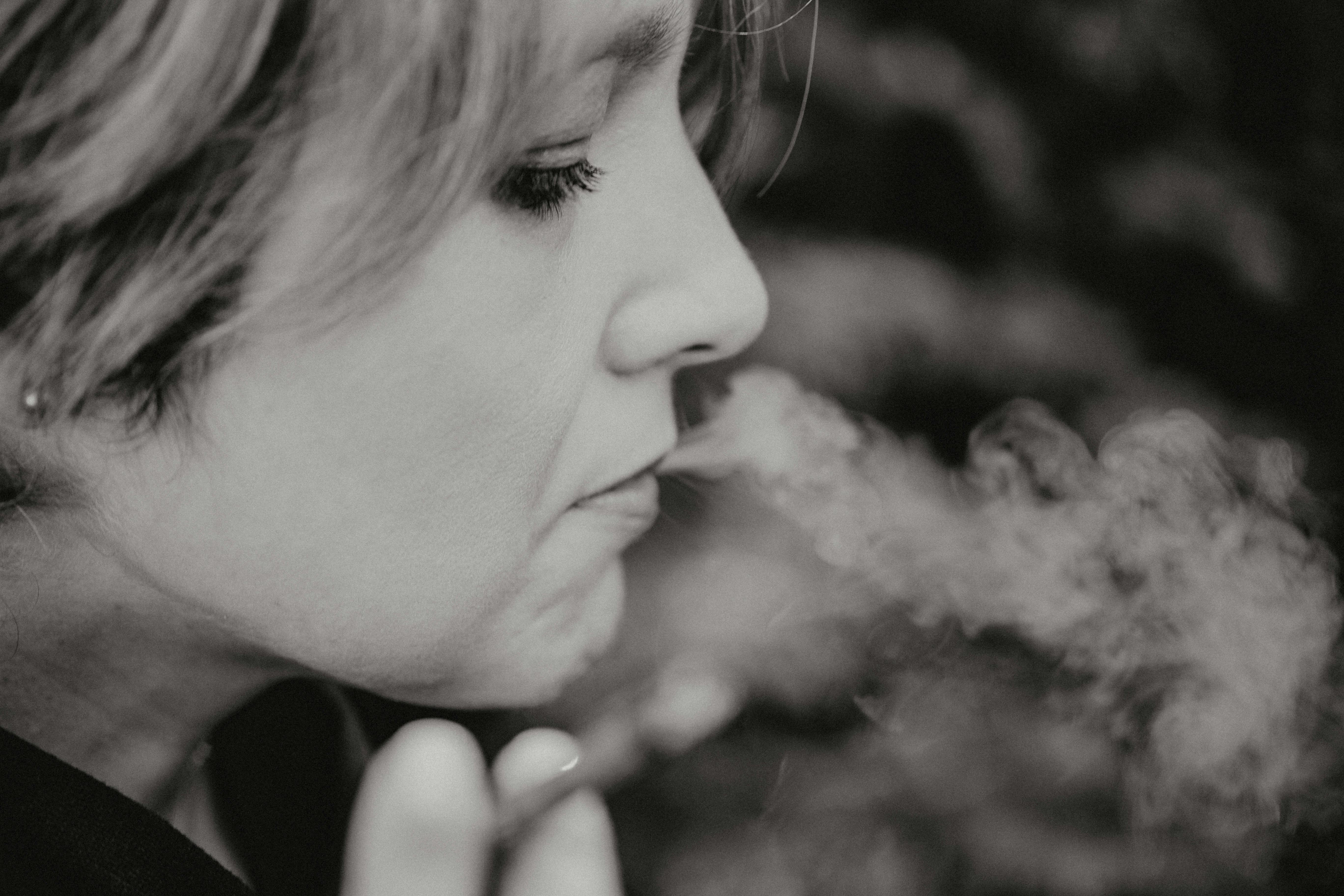Artistic black and white close-up of a woman smoking, capturing dramatic smoke.