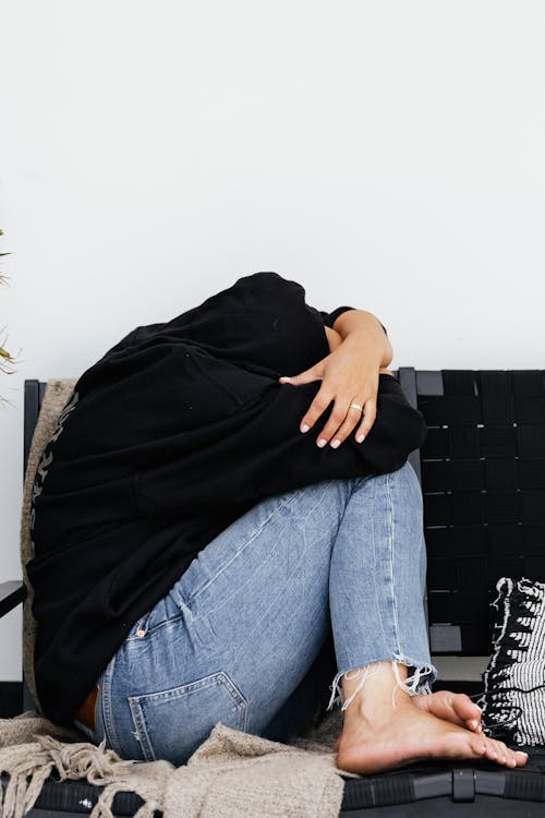 Person Curled up on Sofa · Free Stock Photo