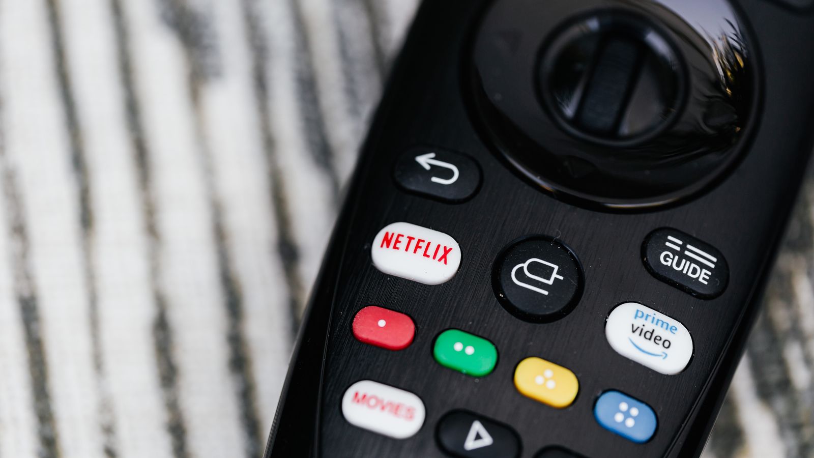 Close-up of a television remote control with streaming and media buttons