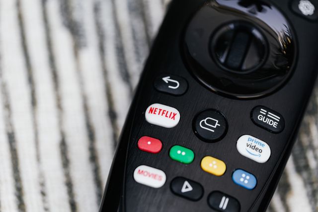 Person relaxing on a couch while using a television remote