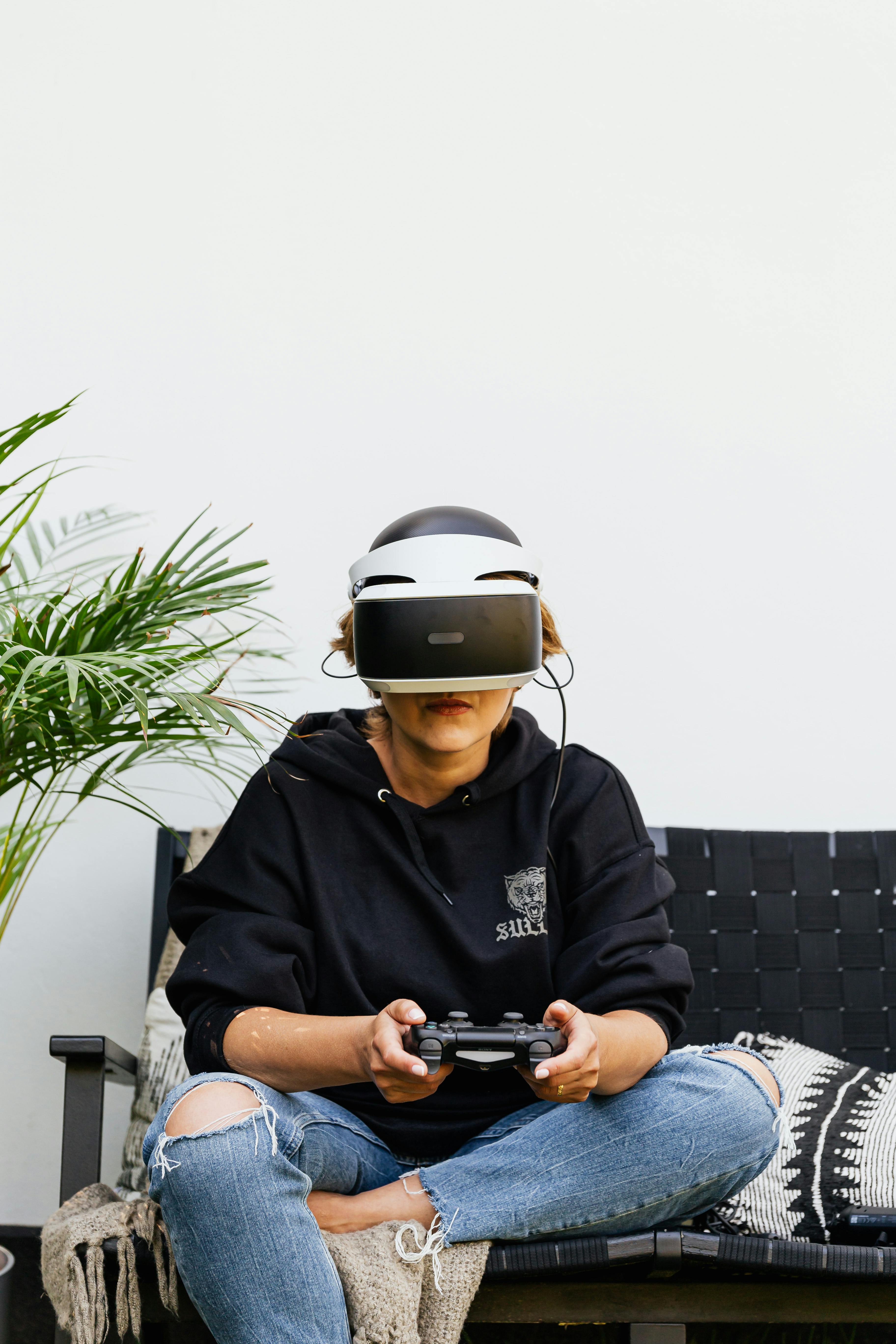 Adult woman relaxing with a VR headset and controller, depicting modern leisure and technology.