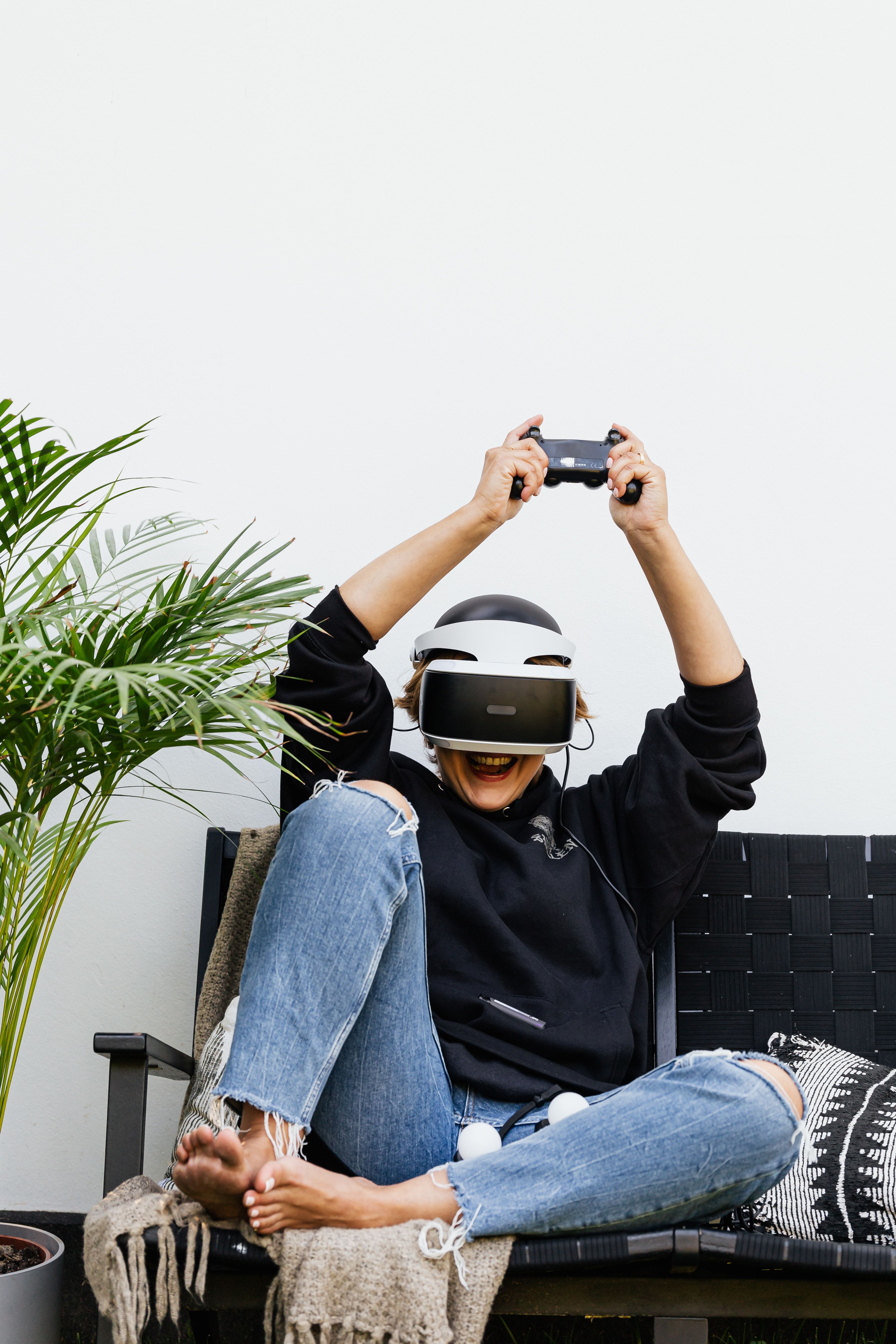 Happy woman enjoying VR gaming in casual relaxed indoor setting.