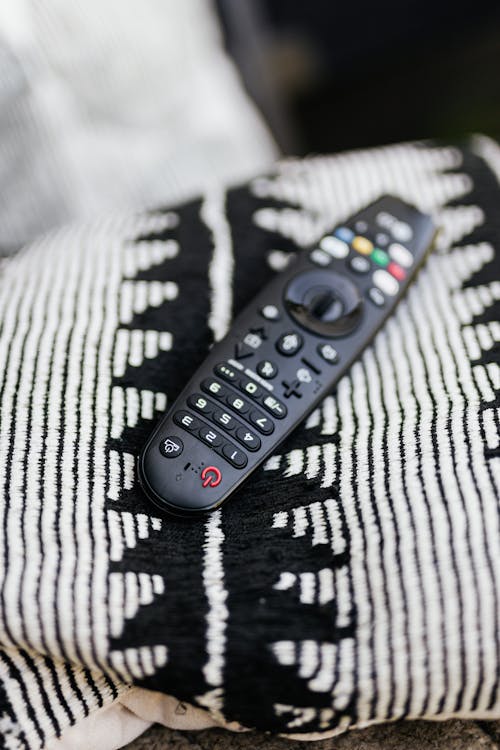 Black Remote Control on White and Black Throw Pillow 