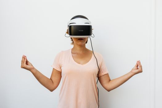 一位戴着虚拟现实护目镜的女性正在室内冥想