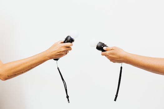 Two hands holding VR controllers against a white background, showcasing virtual reality technology.