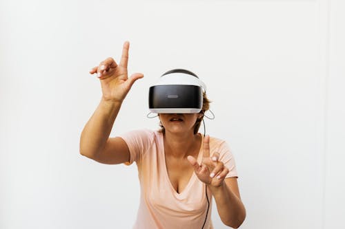 Free Woman in White Tank Top Wearing White and Black Vr Headset Stock Photo