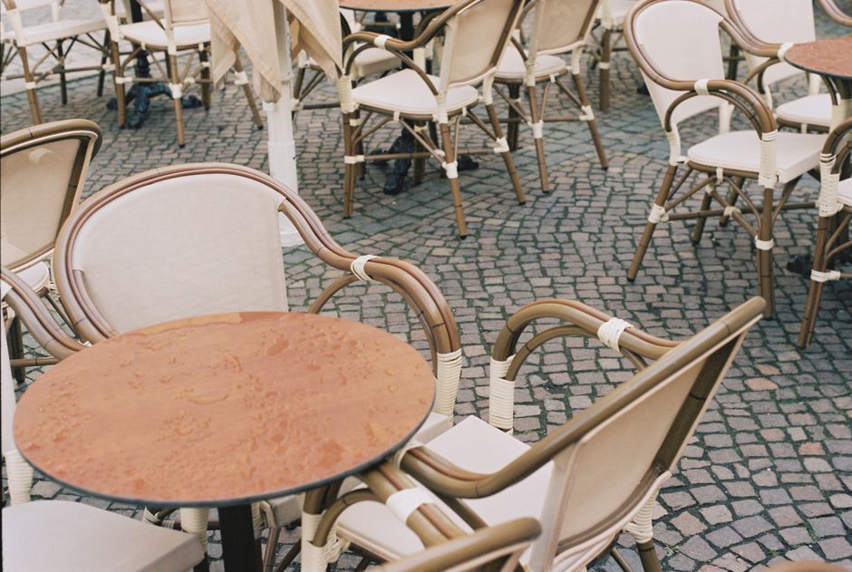 A bustling outdoor café terrace, or <span class="notranslate"><em>esplanada</em></span>, filled with lively conversations and warm sunlight.