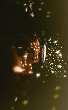 这张艺术照片中，星光投影照亮的脸庞营造出神秘的氛围