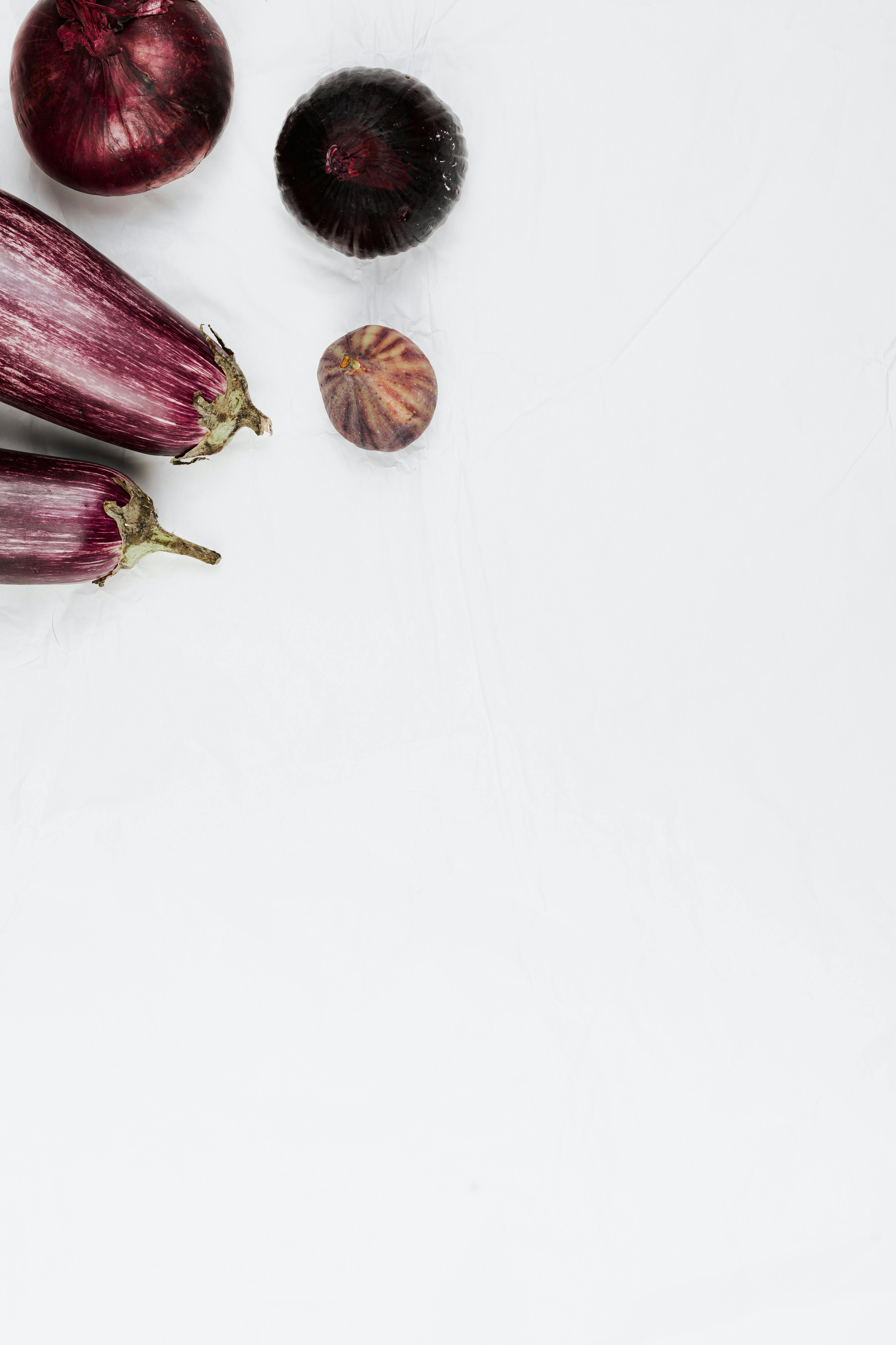 白色背景上平躺的极简主义茄子和洋葱，非常适合烹饪和食品主题