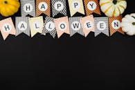 黑色背景上的彩色万圣节横幅与南瓜提供了充足的复制空间