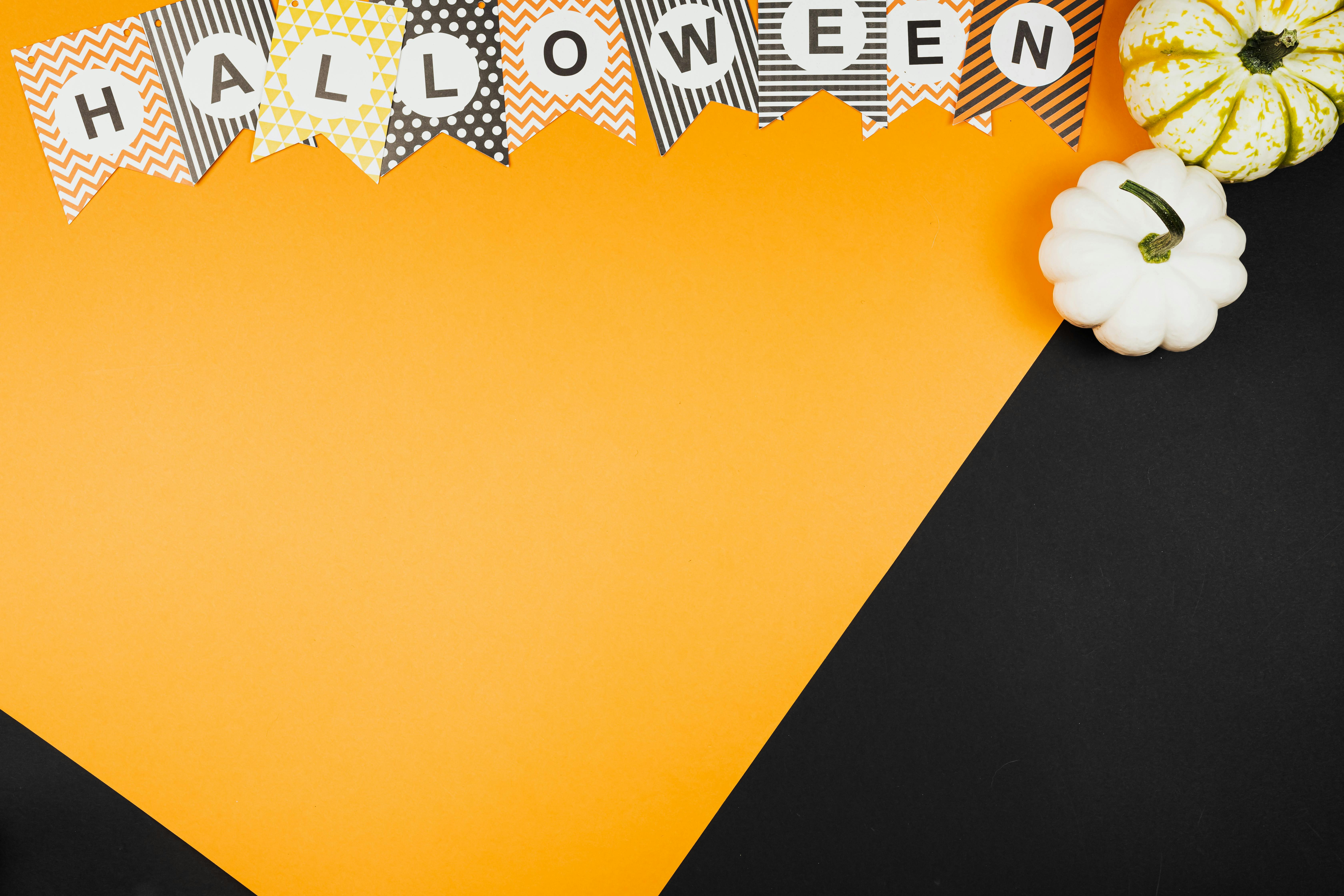 Halloween themed design featuring pumpkins and banners on an orange and black background.