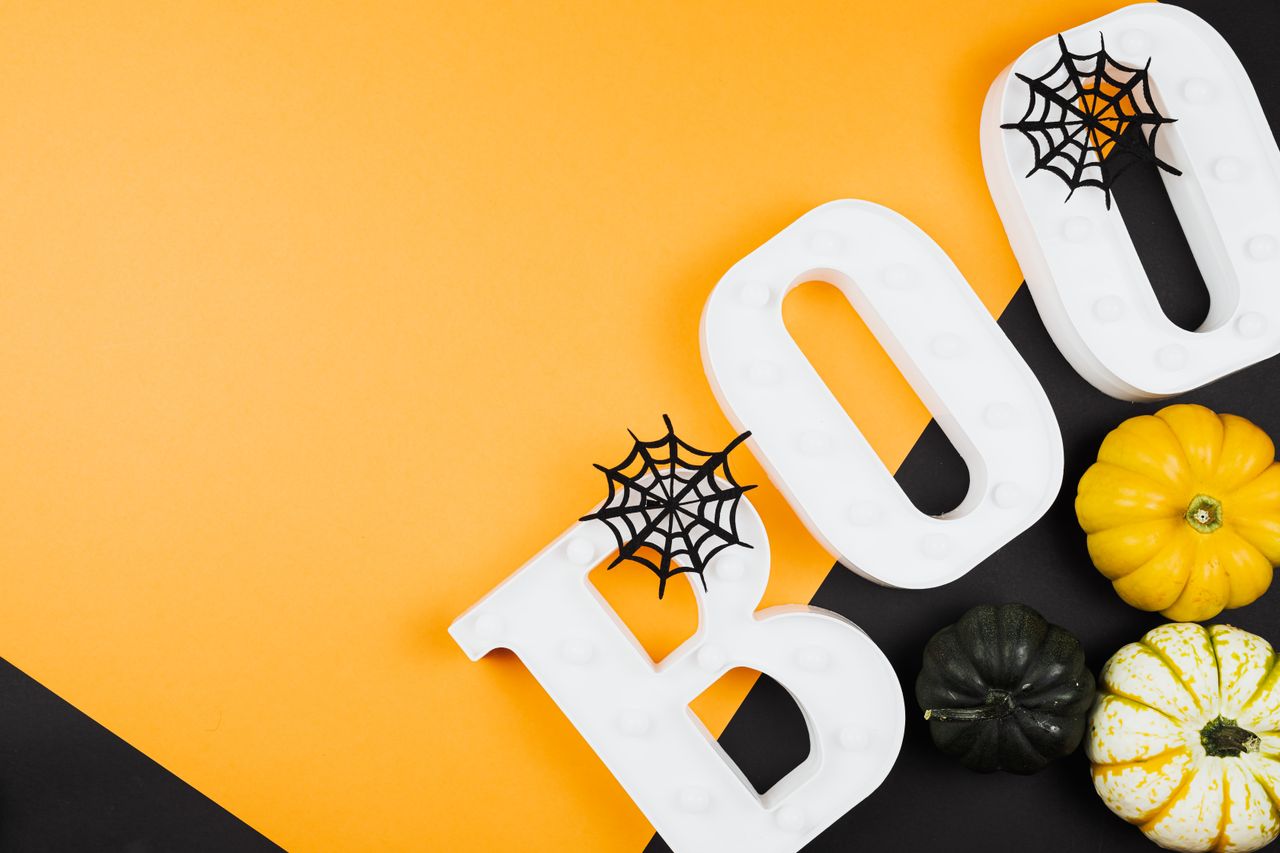 festive halloween arrangement with pumpkins cobwebs and boo letters on