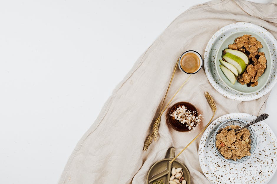 A flat lay of a nutritious breakfast featuring cereal bowls with fresh fruits, espresso, and nuts.
