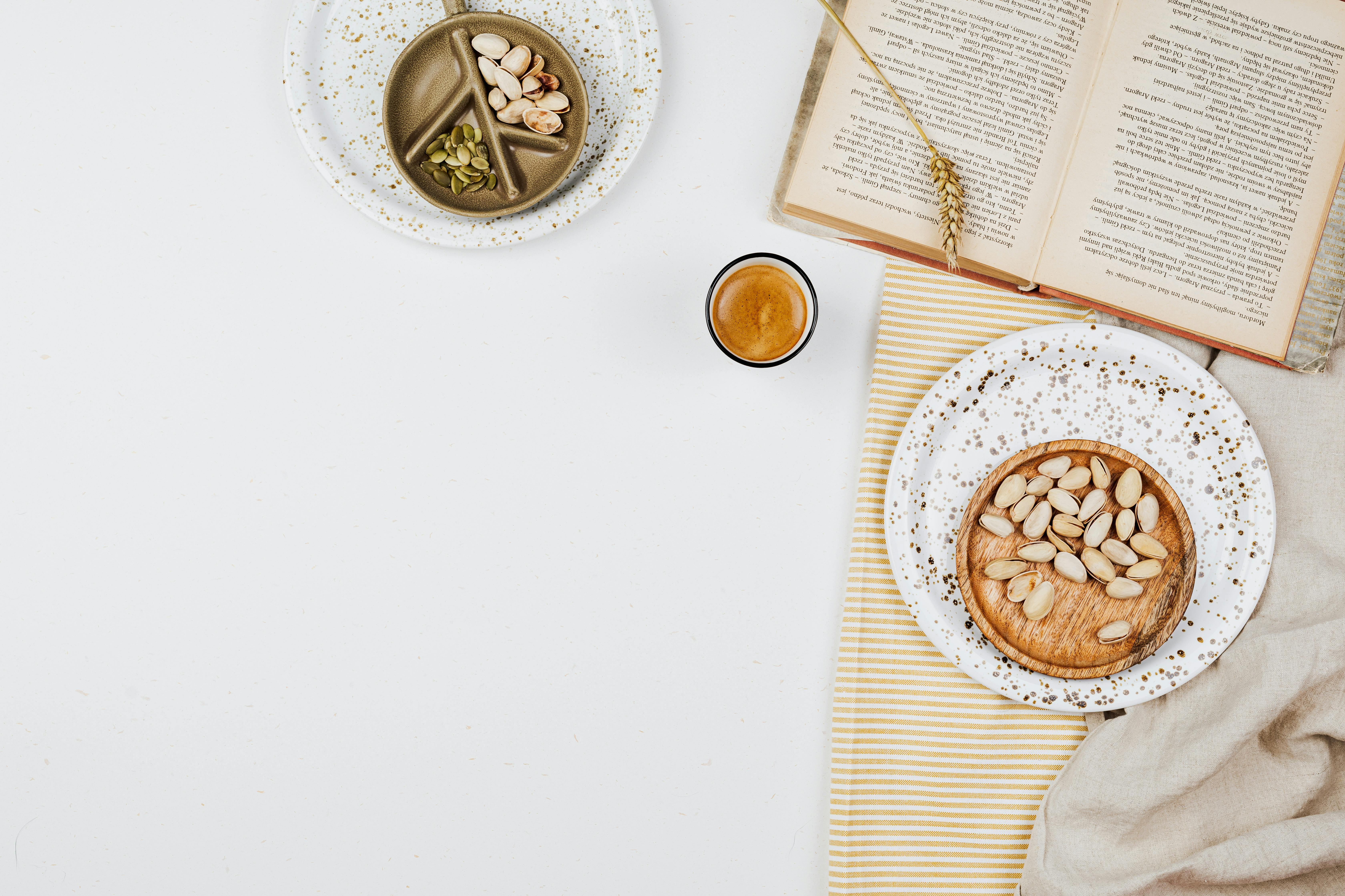 乡村场景中，坚果与饮料的顶视图旁放着一本打开的书，完美诠释了食物与生活方式的概念