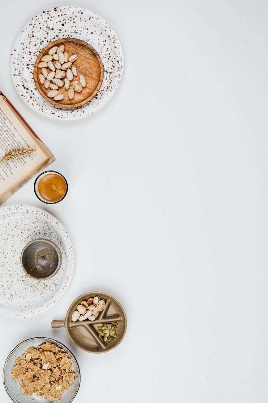 Flat lay of assorted nuts and seeds with empty space on a white background.