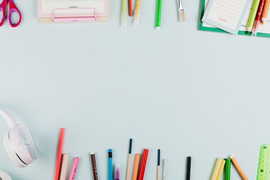 A vibrant flat lay of stationery items with ample copy space on a pastel surface.