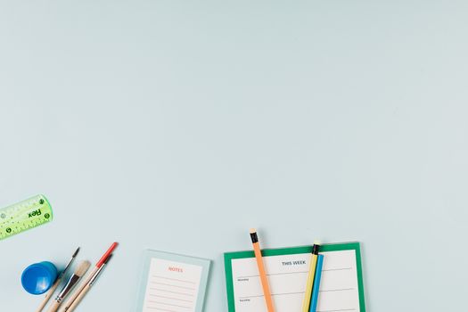 学校用品的艺术安排包括铅笔、尺子和记事本，并留有充足的复印空间