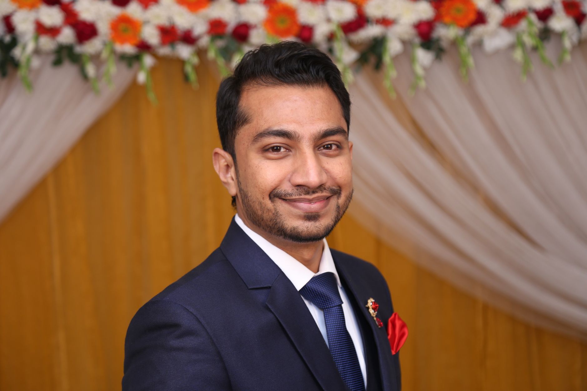 Close-up of a smiling man in a suit at a formal event in Dhaka, Bangladesh.