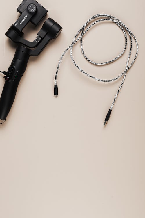 Flat Lay Shot of a Selfie Stick and a Usb Cable