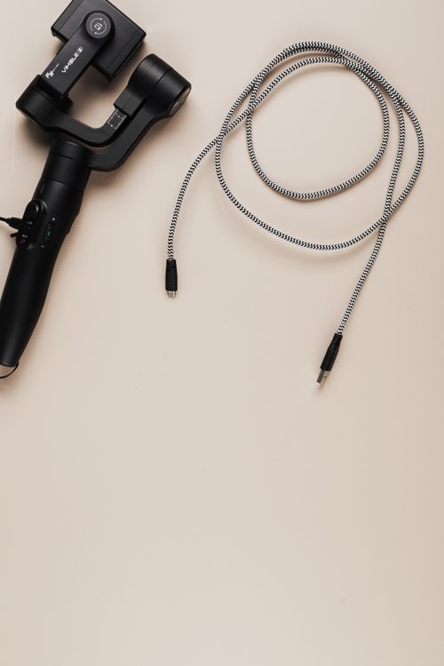 Free Flat lay of a gimbal and USB cable on a neutral background for tech-themed projects. Stock Photo