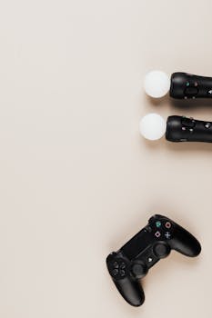 Top view of black video game controllers on a beige background, offering copy space.