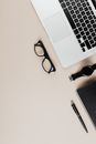 Black Framed Eyeglasses Beside Macbook Pro and Black Framed Eyeglasses