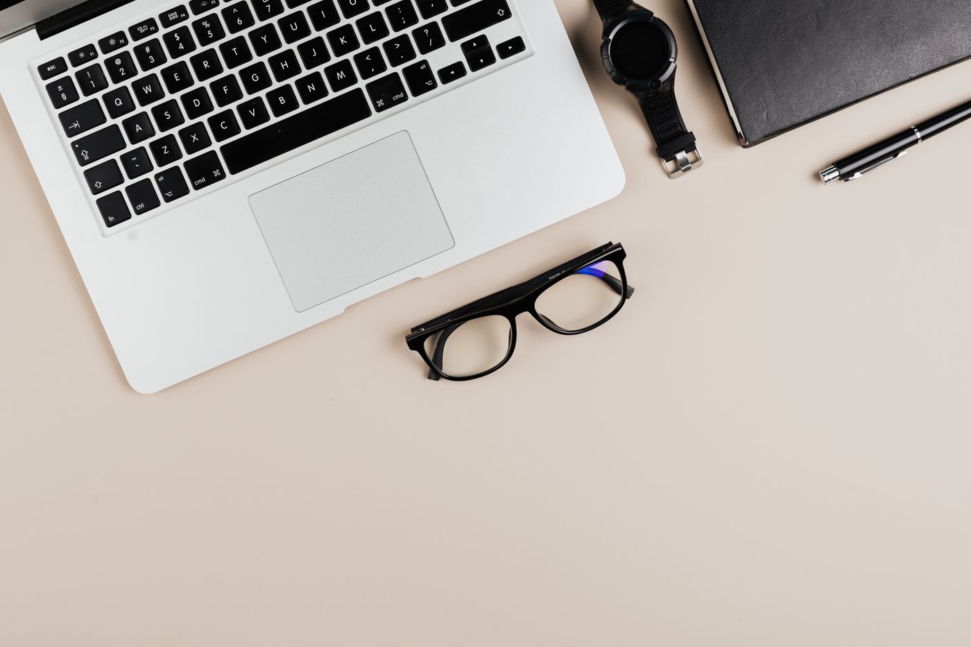 Laptop and glasses flatlay representing business planning and startup budgeting.