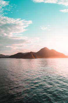 Breathtaking sunset view of a mountain in Rio de Janeiro, Brasil with sunrays reflecting over the sea.