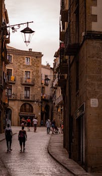 Charming cobblestone street scene in Solsona, Spain with historic architecture and tourists exploring.