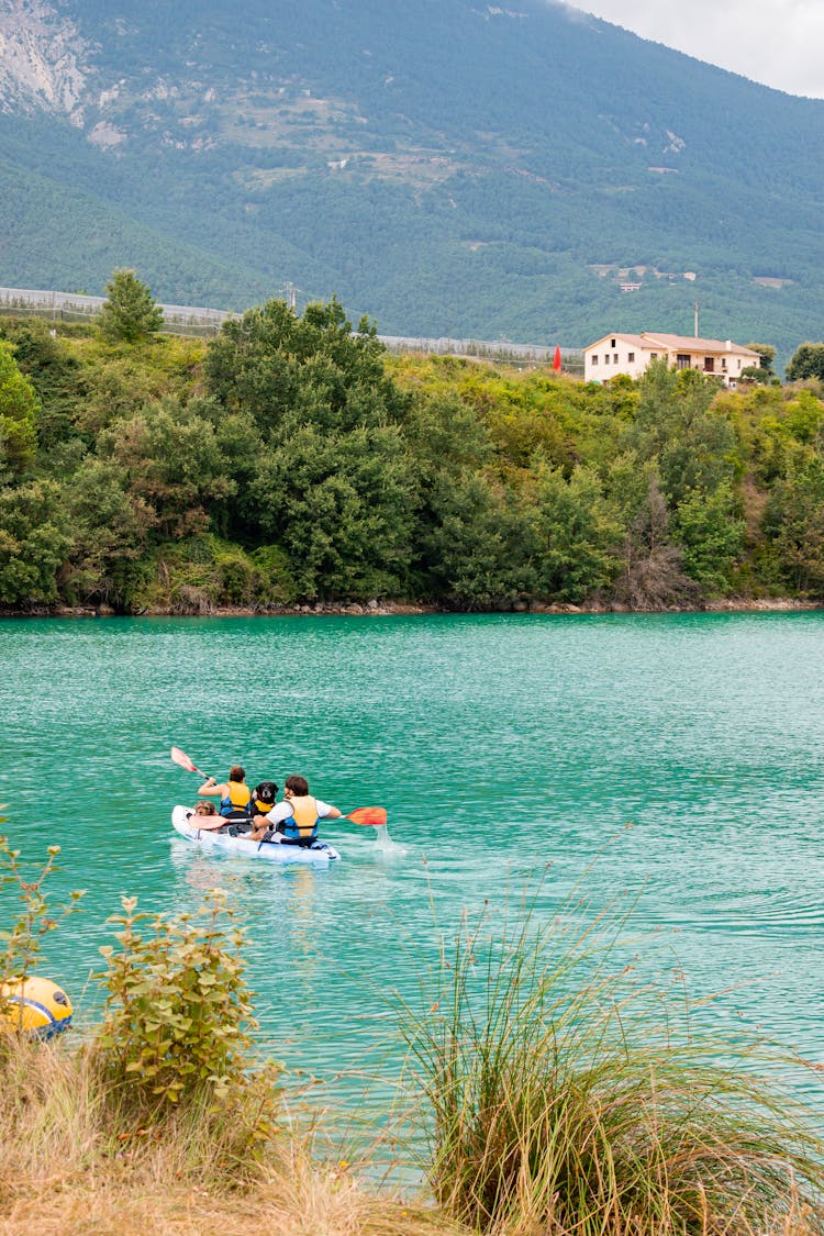 A Couple Paddling A Kayak In The Lake